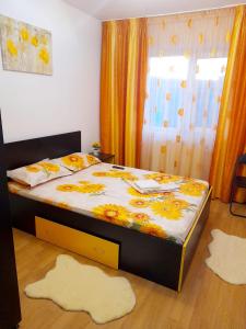 um quarto com uma cama e dois tapetes no chão em Apartament Modern Family em Tîrgu Ocna