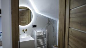 La salle de bains est pourvue d'un miroir et d'un lavabo. dans l'établissement Beskid Rose & SPA, à Słopnice