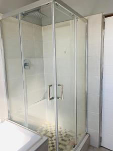 a shower with a glass door in a bathroom at Pule's Home in Maseru