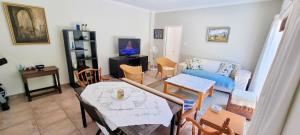 un soggiorno con tavolo e divano di Guinea Fowl poolside apartment a Città del Capo