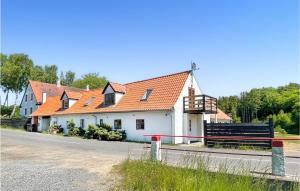 a white house with orange roofs on a street at Cozy Apartment In Gudhjem With Kitchen in Gudhjem