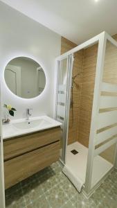 ein Bad mit einem Waschbecken und einer Dusche mit einem Spiegel in der Unterkunft Apartamento Hórreo -San Pelayo- in Cangas de Onís