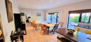 una cucina e un soggiorno con tavolo e sedie di Guinea Fowl poolside apartment a Città del Capo
