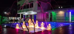 a water fountain in front of a building at night at Blooming Star Guest House in Mandarmoni