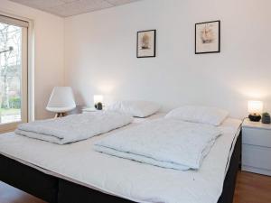 ein weißes Schlafzimmer mit 2 Betten und einem Fenster in der Unterkunft Holiday home Ebeltoft CXCVI in Ebeltoft