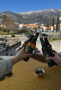 a group of people holding beer bottles on a table at Villa Merci Budva in Budva