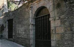un accès à un bâtiment en pierre avec une porte noire dans l'établissement Gite Barry, à Sarlat-la-Canéda 17 autres photos