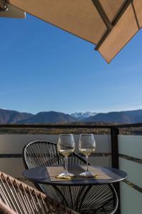 dos copas de vino sentadas en una mesa en un balcón en Pia´s Bleibe, en Caldaro