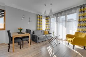a living room with a couch and a table at Sopocka Bryza - Baltica Apartments in Sopot
