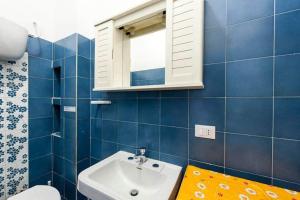 bagno piastrellato blu con lavandino e specchio di Casa Anna a 100mt dal mare a Sperlonga