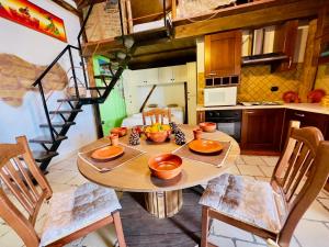una cocina con mesa y sillas y una escalera en Capanna sul Porto, en San Calogero