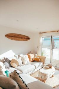 ein Wohnzimmer mit einem weißen Sofa und einem Fenster in der Unterkunft The Hideout - Newquay - Fully Stocked Eco Escape in Newquay