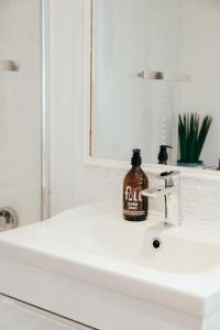 - une bouteille de savon assise au-dessus d'un lavabo dans l'établissement The Hideout - Newquay - Fully Stocked Eco Escape, à Newquay
