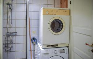 uma máquina de lavar e secar roupa num canto de uma casa de banho em 2 Bedroom Stunning Apartment In Noresund em Noresund