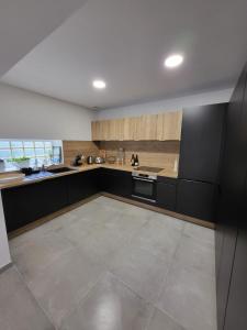 a large kitchen with black cabinets and a tile floor at Bassin d'Arcachon Villa 10 couchages in Andernos-les-Bains