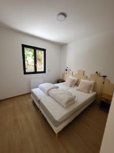 Schlafzimmer mit einem großen weißen Bett und einem Fenster in der Unterkunft Bassin d'Arcachon Villa 10 couchages in Andernos-les-Bains