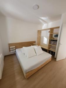 um quarto com uma cama com lençóis brancos e almofadas em Bassin d'Arcachon Villa 10 couchages em Andernos-les-Bains