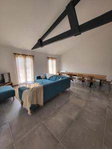 uma grande sala de estar com um sofá azul e uma mesa em Bassin d'Arcachon Villa 10 couchages em Andernos-les-Bains