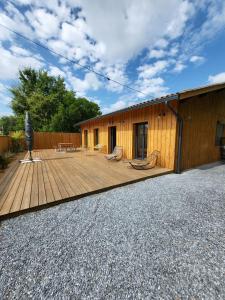 una casa con terraza de madera junto a un edificio en Bassin d'Arcachon Villa 10 couchages en Andernos-les-Bains