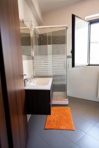a bathroom with a sink and a glass shower at Casa Terra d'Aci in Aci Bonaccorsi