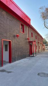 un edificio in mattoni con porte rosse e canestro da basket di JINJU a Yakkasaray