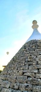 a stone building with a bird on top of it at Trulli Nuova Aia Resort in Alberobello