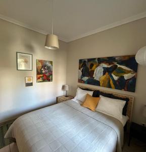 a bedroom with a bed with a painting on the wall at The ART space in Kavala in Kavála