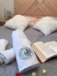 ein Bett mit Handtüchern und ein Buch darauf in der Unterkunft Gorczańska Chatka in Osobie