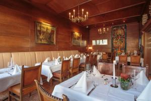 uma sala de jantar com mesas e cadeiras e um lustre em Hotel Rappensberger em Ingolstadt
