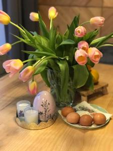 eine Vase mit Blumen und Eiern auf dem Tisch in der Unterkunft Gorczańska Chatka in Osobie