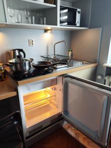 cocina con horno abierto con ollas y sartenes en Apartamenty Duo, en Poznan