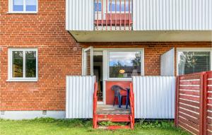 una casa de ladrillo rojo con una valla roja y una silla en Nice Apartment In Hyltebruk With Kitchen en Hyltebruk
