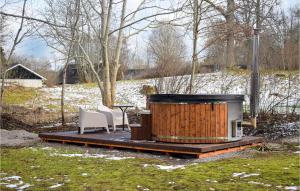 una vasca idromassaggio in legno con due sedie e un tavolo di 4 Bedroom Lovely Apartment In Orrefors a Orrefors