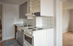 eine weiße Küche mit Herd und Spüle in der Unterkunft 4 Bedroom Lovely Apartment In Orrefors in Orrefors
