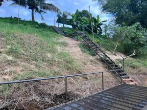 a set of steps leading up a hill with trees at Chalet Terapung Laman Tok Ayah Temerloh in Temerloh