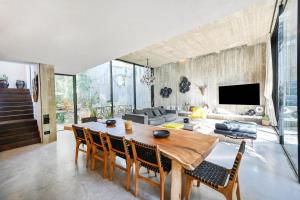 een woonkamer met een houten tafel en stoelen bij The Eucalyptus Mansion by HolyGuest in Tel Aviv