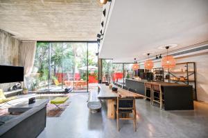 a living room with a table and a large window at The Eucalyptus Mansion by HolyGuest in Tel Aviv