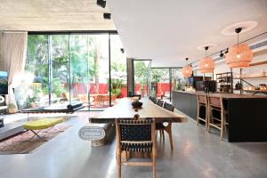 een keuken met een grote houten tafel en stoelen bij The Eucalyptus Mansion by HolyGuest in Tel Aviv