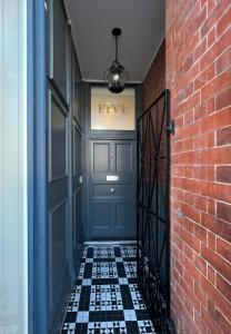 a hallway with a blue door and a brick wall at The Apartments Lytham Square in Lytham St Annes