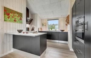 kuchnia z czarnymi szafkami i dużym oknem w obiekcie Pet Friendly Home In Grenaa With Wifi w mieście Brøndstrup