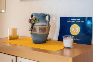 a vase sitting on a counter with a glass of milk at Apartments Darija in Pučišća