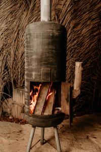 a wood fired oven with a fire in it at סיגליות במדבר in Niẕẕane Sinay