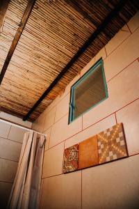 a bathroom with a window and a shower curtain at סיגליות במדבר in Niẕẕane Sinay