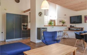 a living room with blue chairs and a kitchen at Awesome Home In Aakirkeby With 4 Bedrooms And Wifi in Vester Sømarken