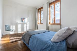um quarto com uma cama com lençóis azuis e janelas em Maison Famille-Confort-Terrasse Jardin-Vue Cathédrale em Amiens