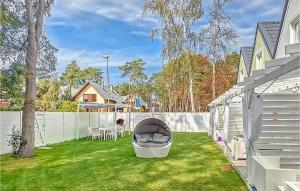 a backyard with a chair on the grass at Amazing Home In Miedzywodzie With Kitchen in Międzywodzie