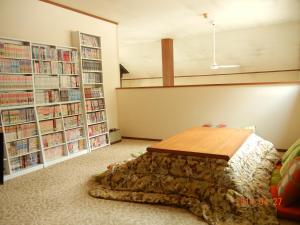 a room with a table and book shelves with books at Sakka Sanso in Hakuba