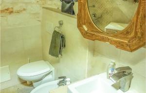 uma casa de banho com um WC, um lavatório e um espelho. em Nice Home In Martina Franca With Kitchen em Martina Franca