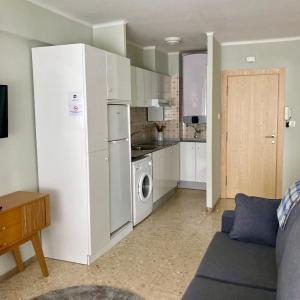 een keuken met een koelkast, een wasmachine en een droger bij Apartamentos Angelito in Playa América