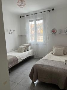 een slaapkamer met 2 bedden en een raam bij Villa climatisé avec piscine et jacuzzi in Carpentras